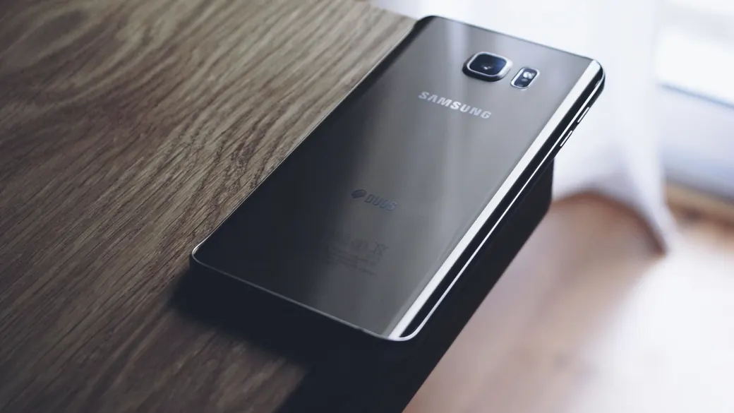 窓辺の木のテーブルに置かれたスマートフォン